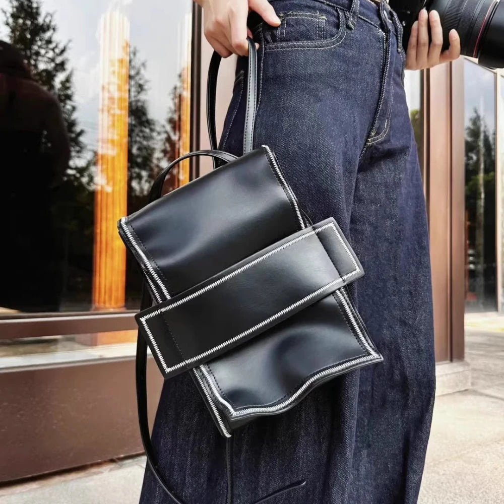 The Somlord 2-in-1 Convertible Leather Mini Backpack is elegantly styled as a shoulder bag, paired with casual denim attire, showcasing its versatility and adaptability for city life.