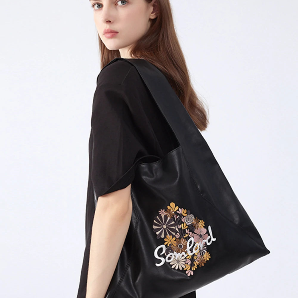 Stylish everyday wear – the Artistic Embroidered Triangle Tote complements neutral outfits with its sleek design and detailed embroidery.