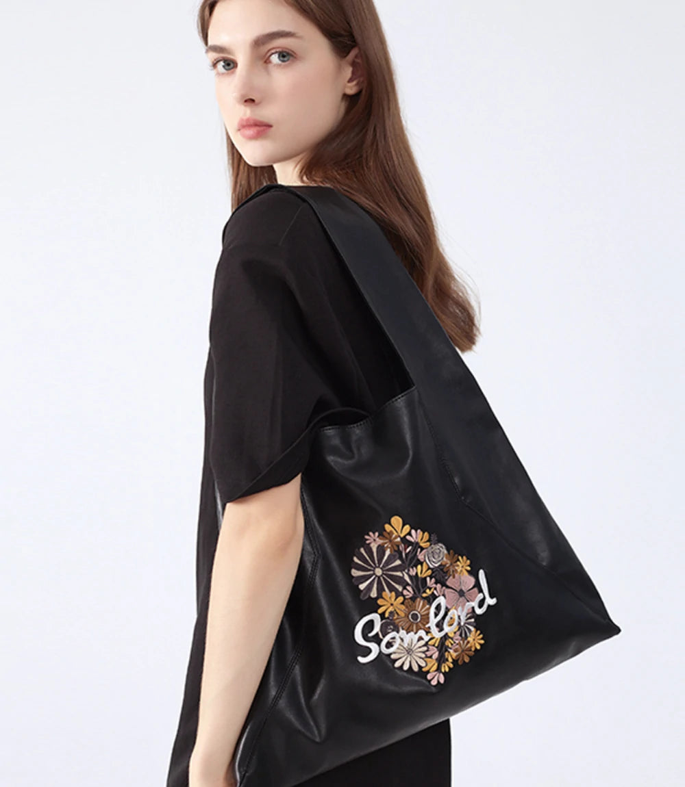 Stylish everyday wear – the Artistic Embroidered Triangle Tote complements neutral outfits with its sleek design and detailed embroidery.