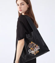 Stylish everyday wear – the Artistic Embroidered Triangle Tote complements neutral outfits with its sleek design and detailed embroidery.