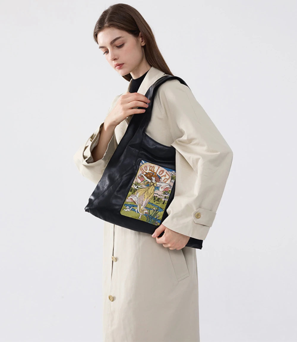 Chic and casual – the Artistic Embroidered Triangle Soft Leather Tote Bag styled with a long coat for an elevated look.