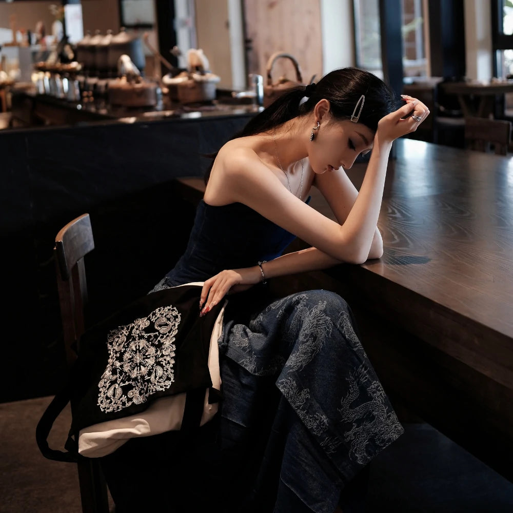 Somlord Artistic Slouchy Embroidered Crossbody Bag elegantly placed in a serene café setting, featuring intricate embroidery and a relaxed silhouette, complementing the urban chic style.