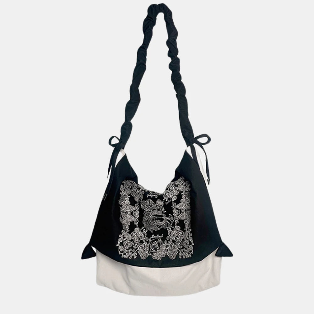 Artistic Slouchy Embroidered Crossbody Bag – black-and-white soft tote with intricate paisley embroidery, featuring a ruched strap and relaxed silhouette.