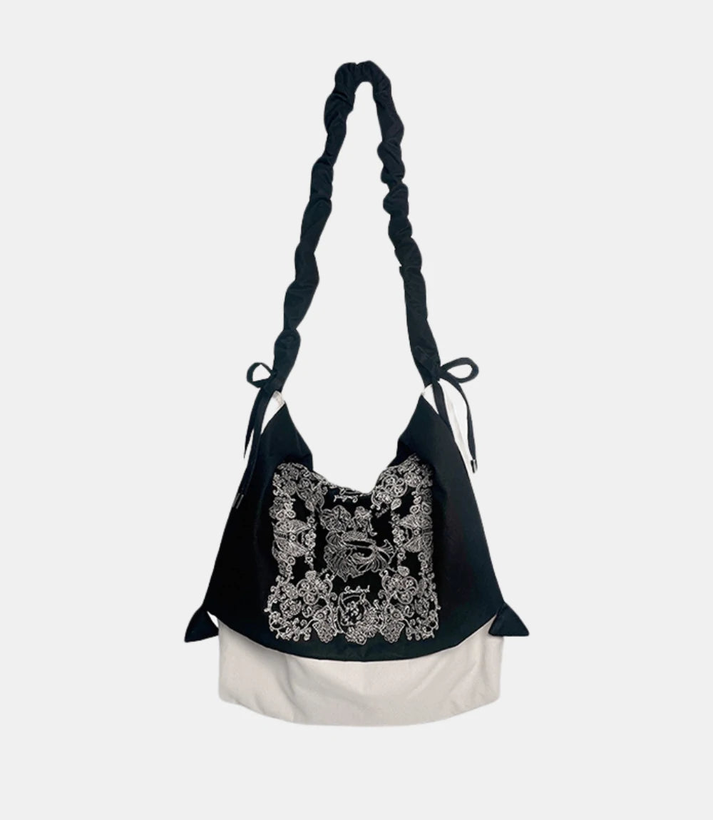 Artistic Slouchy Embroidered Crossbody Bag – black-and-white soft tote with intricate paisley embroidery, featuring a ruched strap and relaxed silhouette.