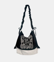 Artistic Slouchy Embroidered Crossbody Bag – black-and-white soft tote with intricate paisley embroidery, featuring a ruched strap and relaxed silhouette.