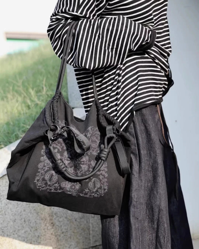 Somlord Black Embroidered Tote Bag – Model carrying a stylish black tote with intricate paisley embroidery, perfect for everyday use and urban fashion scenes.