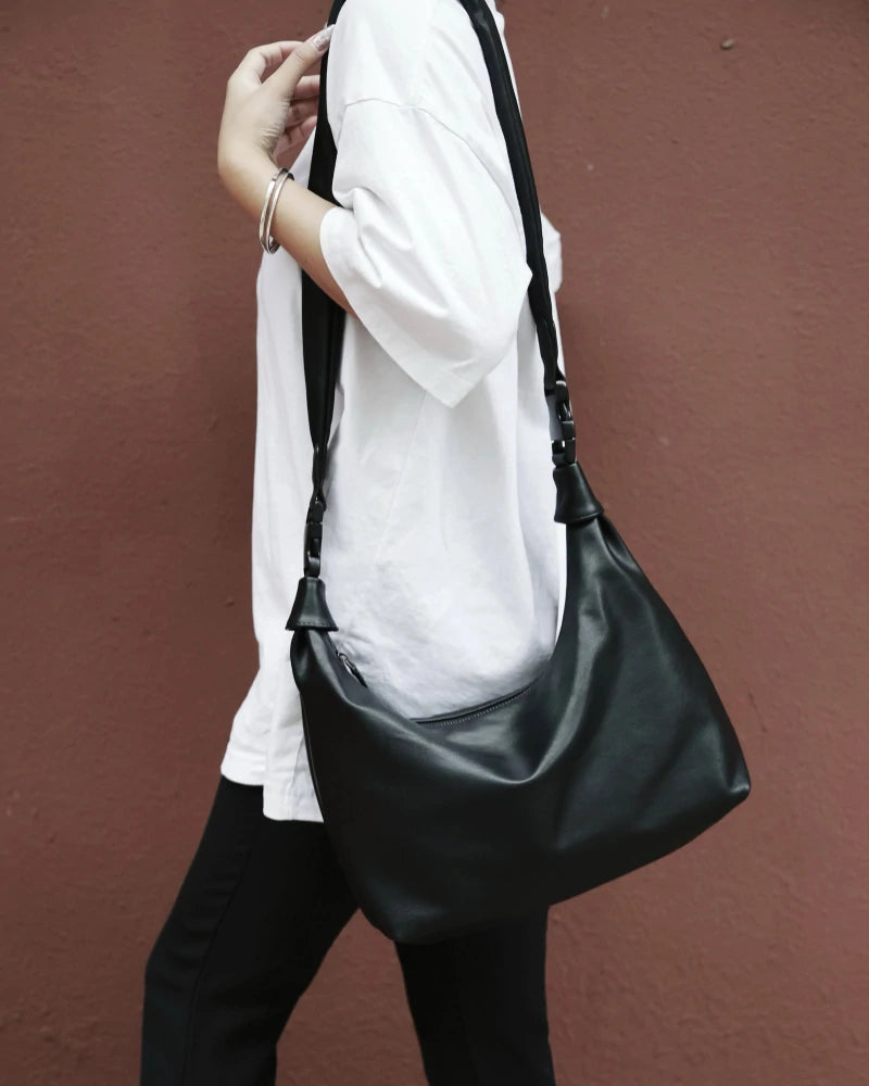 Somlord Retro Black Leather Hobo Bag – Elegant black leather hobo bag worn crossbody, ideal for urban street style and casual fashion.