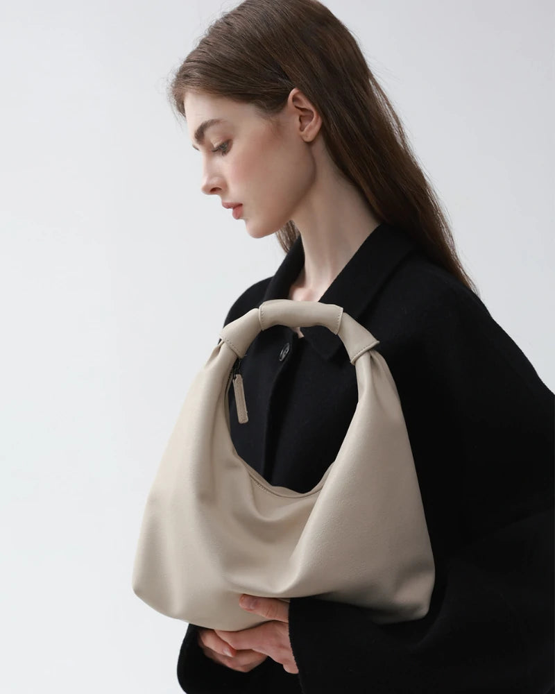 Somlord Cream Leather Cloud Hobo Bag – Close-up of model holding a soft cream leather hobo bag, showcasing minimalist design and premium craftsmanship.