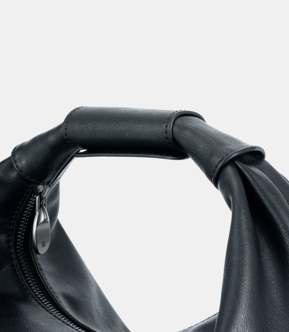 Close-up of reinforced hand-stitched leather handle – adaptable for casual and formal looks, ensuring effortless sophistication.