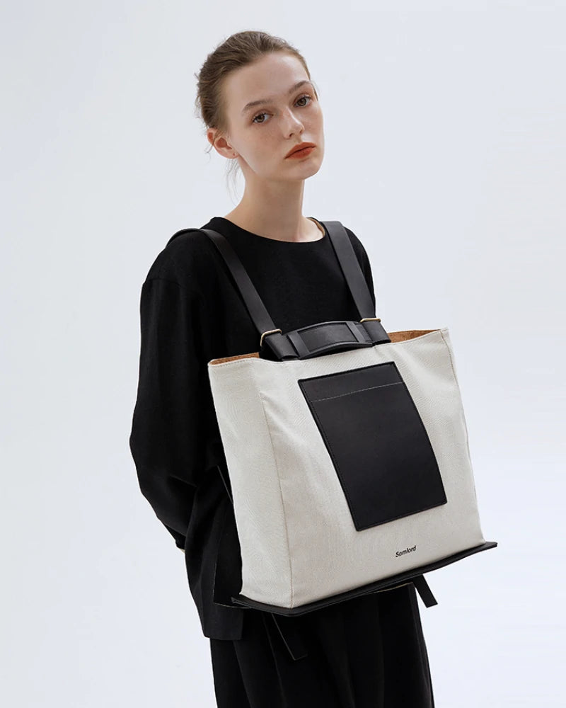 Somlord Structured Canvas Tote Backpack – Elegant model carrying a versatile canvas tote backpack, black leather accents, designed for everyday and travel use.