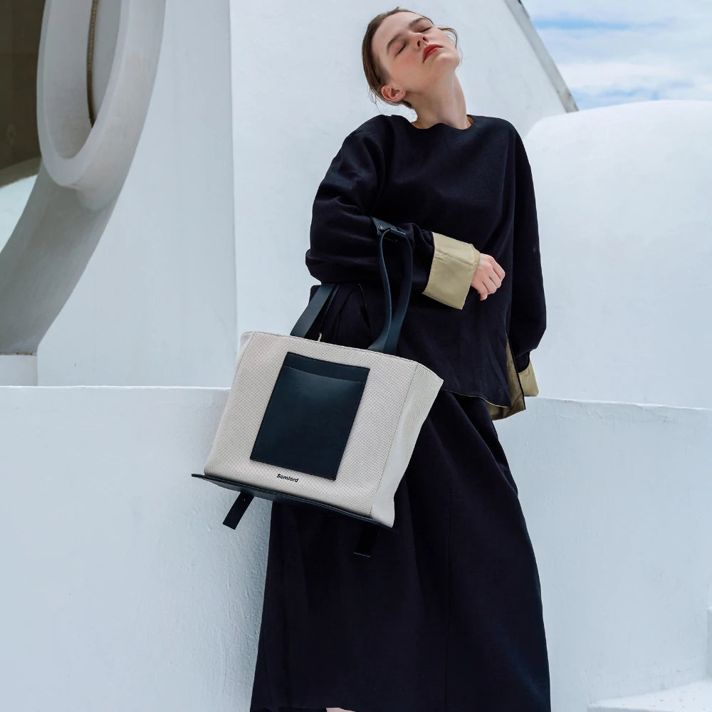 Somlord Structured Canvas Tote Backpack – Model posing with an elegant canvas tote, sleek black leather accents, ideal for modern urban lifestyle and travel.