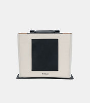 Minimalist canvas tote backpack – structured silhouette with a sleek black pocket, ideal for work, travel, and daily essentials.